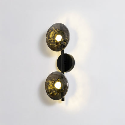 Contemporary wall light in black and gold metal finish with dual globe shades for bedroom or living decor lighting white background.
