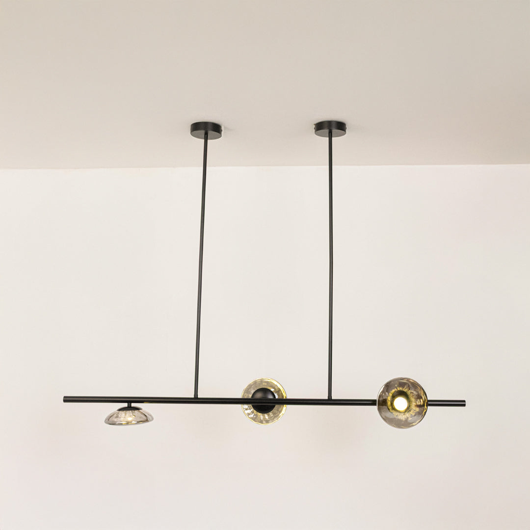 Black metal linear chandelier with circular glass accents designed for sleek modern ceiling lighting in contemporary interiors.