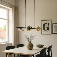 Black metal linear chandelier with smoky glass shades adding warm glow and modern elegance to dining room ceiling decor.