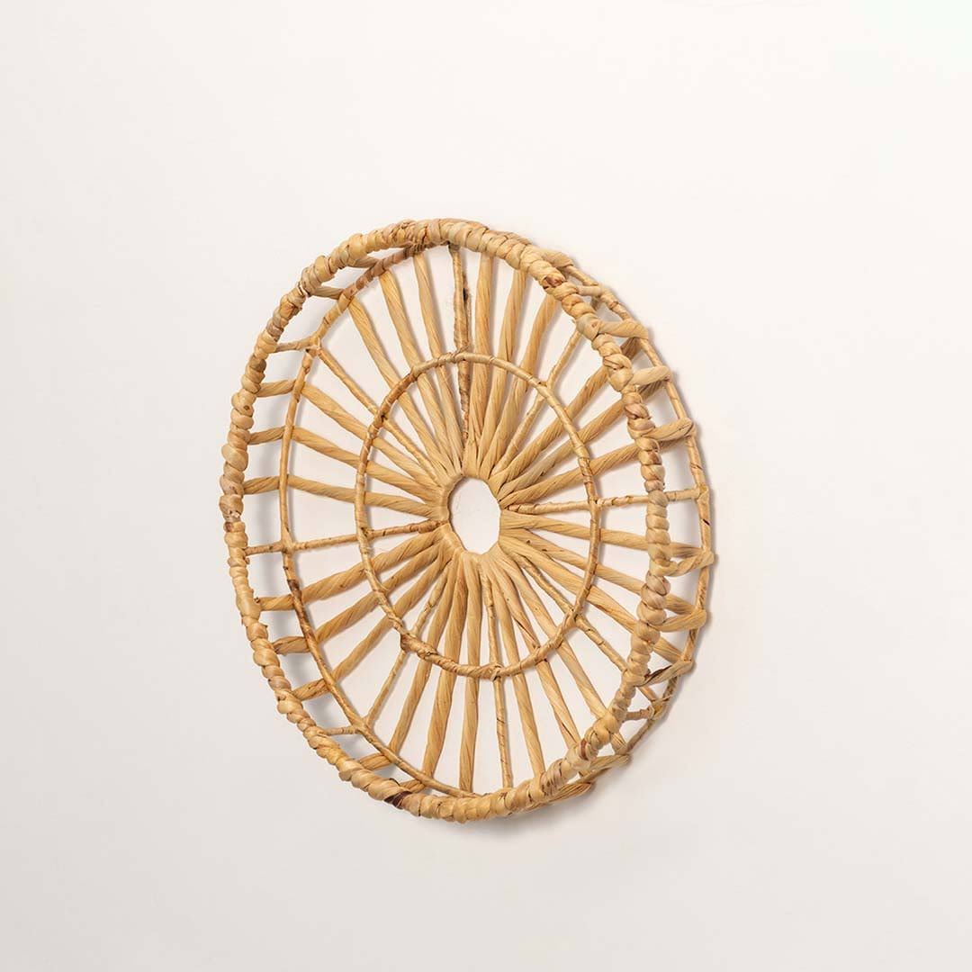Side view of handcrafted natural rattan open center web wall basket wheel panel for modern bohemian home wall decor styling.