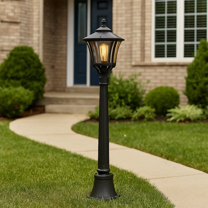 Traditional black metal post lamp standing tall in outdoor garden setting creating vintage street light ambiance decor.