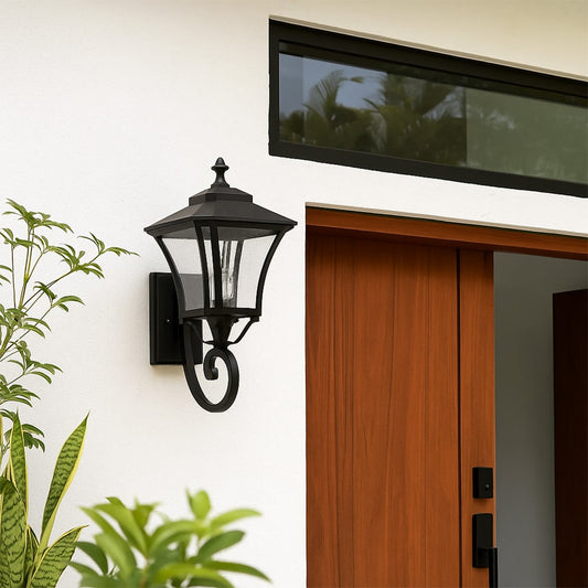 Outdoor wall lantern in black metal mounted beside wooden door adding warm welcoming glow and classic charm to exterior home facade.