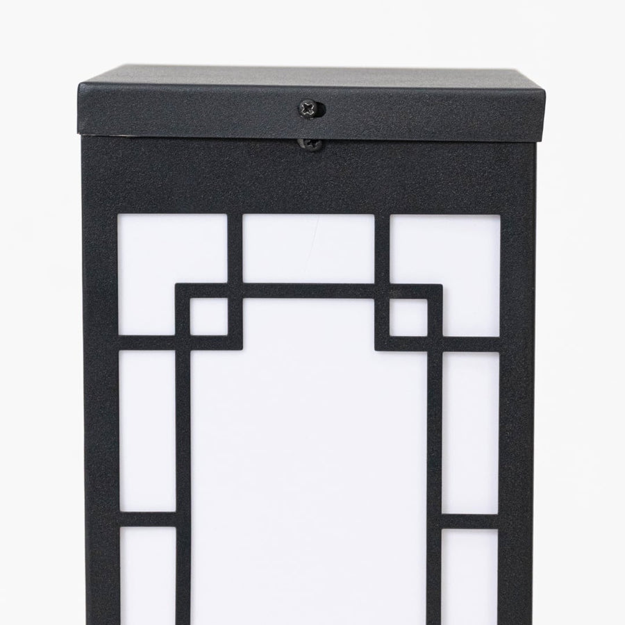 Closeup of black outdoor wall lantern showing geometric frame frosted glass panel and clean contemporary exterior design.