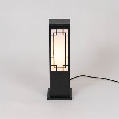 Black outdoor bollard light with geometric frosted panels for modern exterior decor use.