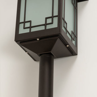 Zoomed view of brown solar powered garden lantern capturing frosted glass glow and structured spike design perfect for pathways and flower beds.