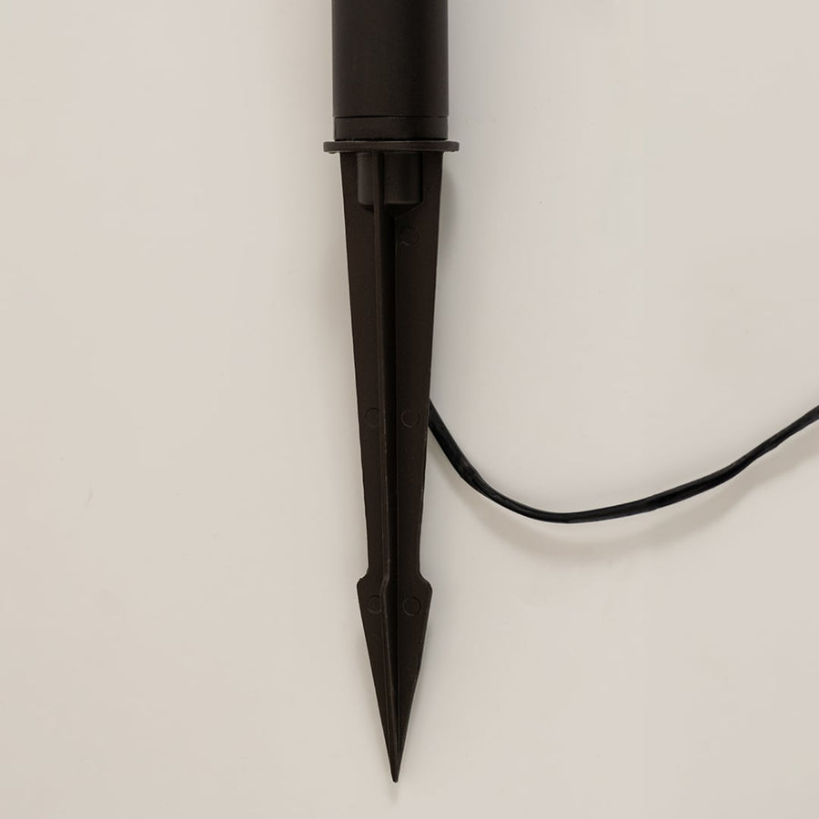Detailed closeup of brown outdoor spike lantern highlighting its frosted panels geometric frame and solar top ideal for decorative landscape lighting.
