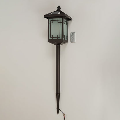 Brown solar powered garden spike lantern with frosted patterned glass shown with light off on a white background displaying its tall spike frame and classic style.