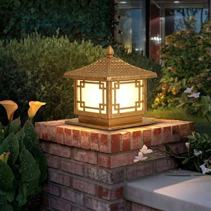Outdoor pillar light installed on brick column in garden setting creating warm ambient lighting for pathway and exterior decor.