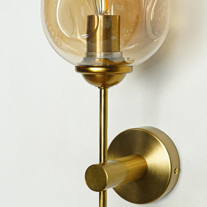 Elegant brass wall light with amber glass shade and sleek metallic finish for luxury interior decor.