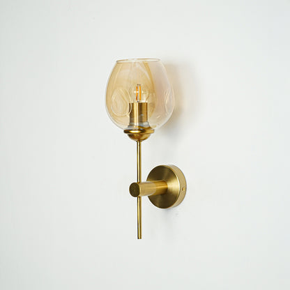 Modern brass wall light with amber glass shade for elegant bedroom and hallway interior decor.