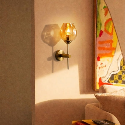 Modern brass wall light with amber glass shade creating warm cozy living room interior ambiance.