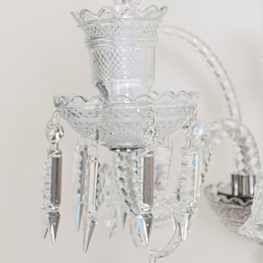 Closeup of crystal wall light with detailed glass shade and crystal accents for elegant wall decor.