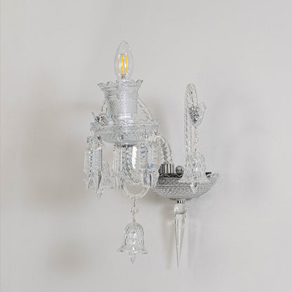 Crystal wall light with ornate glass shade and crystal detailing turned off on white background decor.