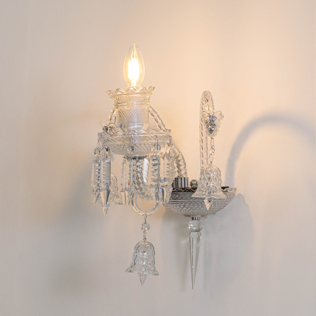 Modern crystal wall light in chrome finish with candle bulbs for bedroom or living decor lighting white background.