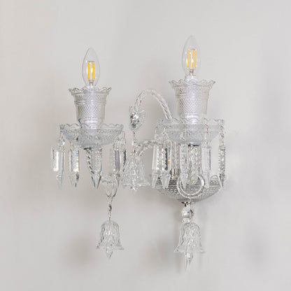 Double arm crystal wall light with detailed glass design and crystal drops turned off on white background.