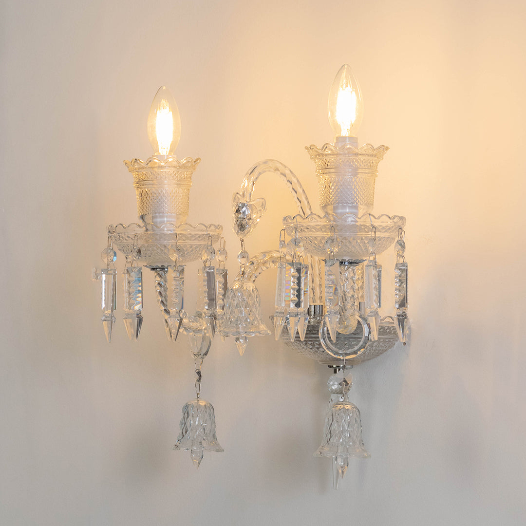 Decorative crystal wall light in clear finish with candle bulbs for living room or hallway decor lighting white background.