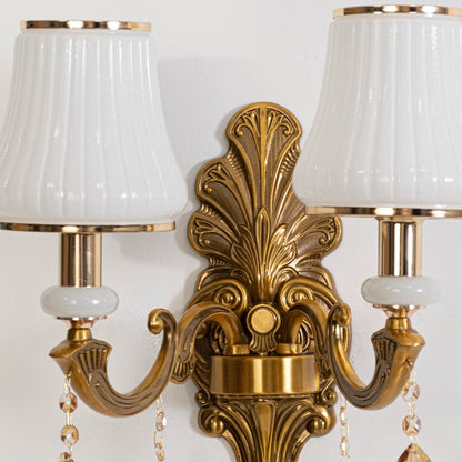 Closeup of two light crystal sconce with detailed gold base white pleated shades and hanging crystal accents.