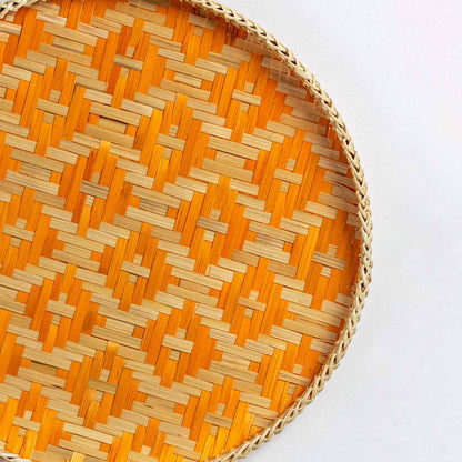 Closeup of handcrafted orange and natural seagrass wall basket with geometric woven pattern for artisan home décor.
