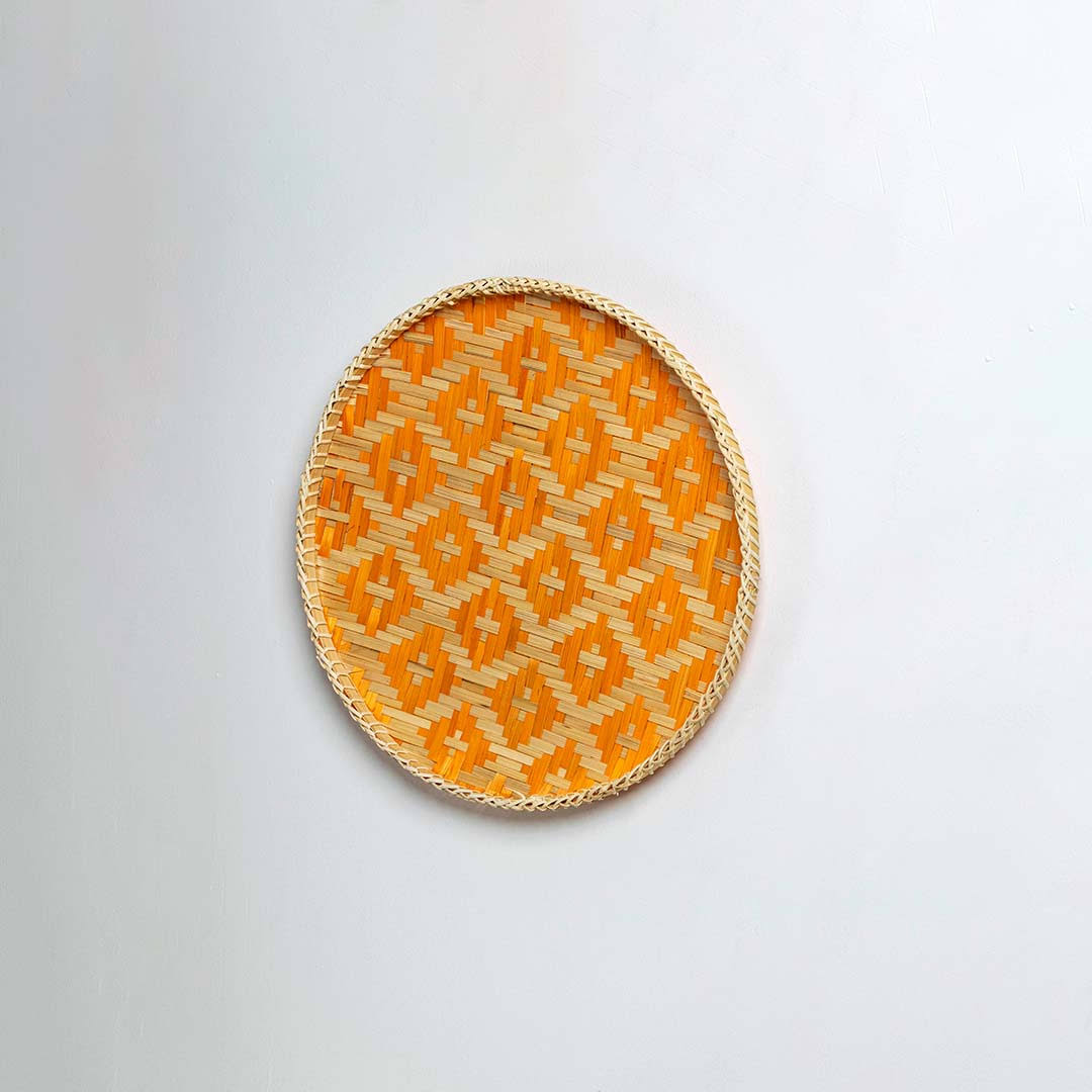 Natural woven orange and beige seagrass wall basket for living room boho décor on white background image.