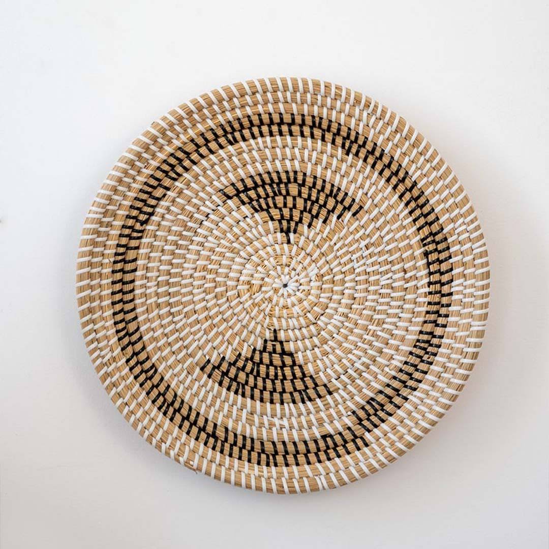Handwoven seagrass wall basket decor styled in a modern bedroom creating warm natural boho wall decoration.