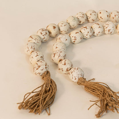 Close-up of speckled bead garland showing unique handcrafted bead detailing and natural jute tassel design.