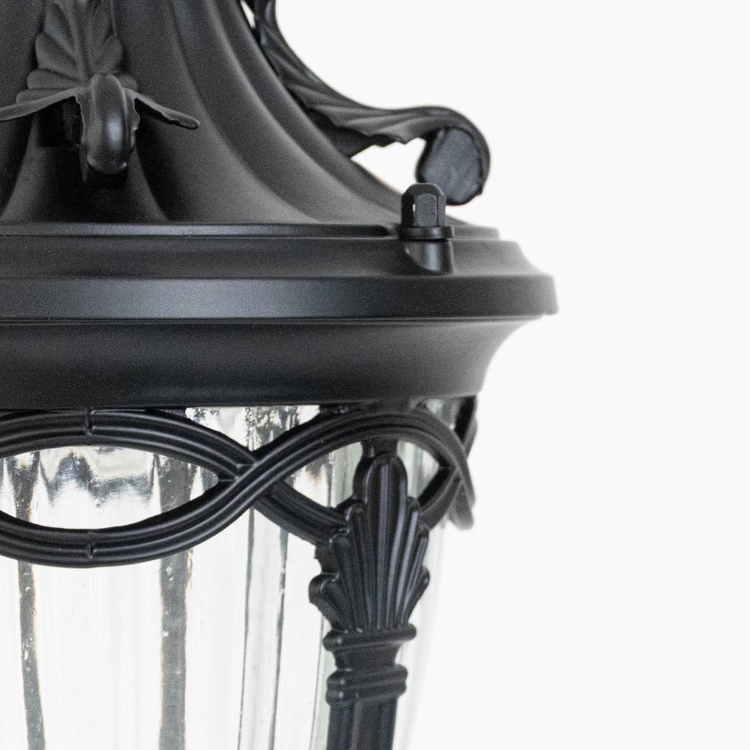 Close up view of the decorative metal rings and inner glass globe of the black spherical cage pendant light fixture.