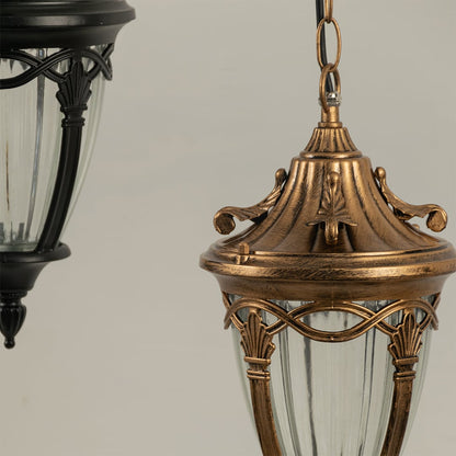 Detailed closeup of antique gold metal lantern showcasing ornate top design and ribbed glass shade for outdoor decor.