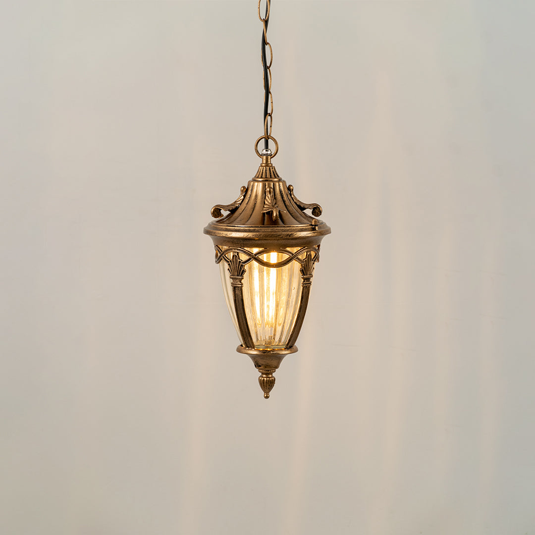 Gold metal hanging outdoor lantern with glass panels glowing on white background ideal for porch entrance and exterior decor lighting.