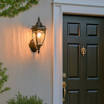 Black classic outdoor wall lantern with the light on casting a warm glow beside the entrance door creating an elegant and inviting exterior ambiance for the home.