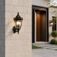 Classic black iron ornate glass carriage wall sconce lantern on light stone brick pillar for modern villa patio pathway.