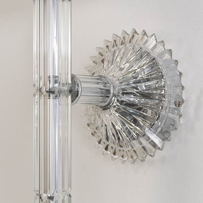Closeup of wall light with chrome base fabric shade and crystal drop accent for modern home decoration.