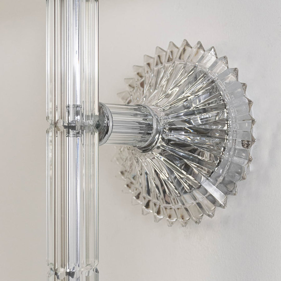 Closeup of wall light with chrome base fabric shade and crystal drop accent for modern home decoration.
