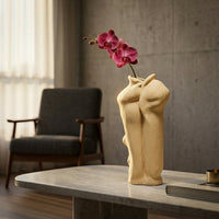 Beige ceramic abstract body vase styled with orchid blooms for elegant modern home decor placement.