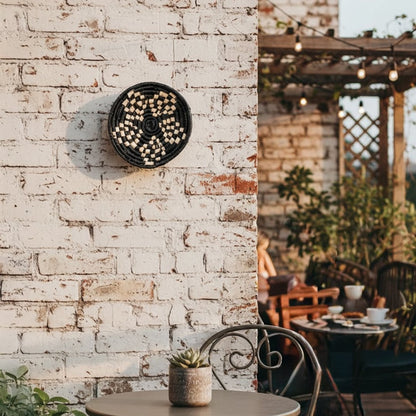 Minimal round wall decor with botanical design placed against exposed brick backdrop creating organic focal point for modern rustic wall styling.