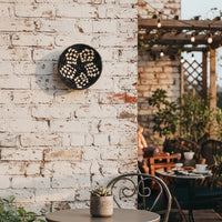 Minimal round wall decor with botanical design placed against exposed brick backdrop creating organic focal point for modern rustic wall styling.