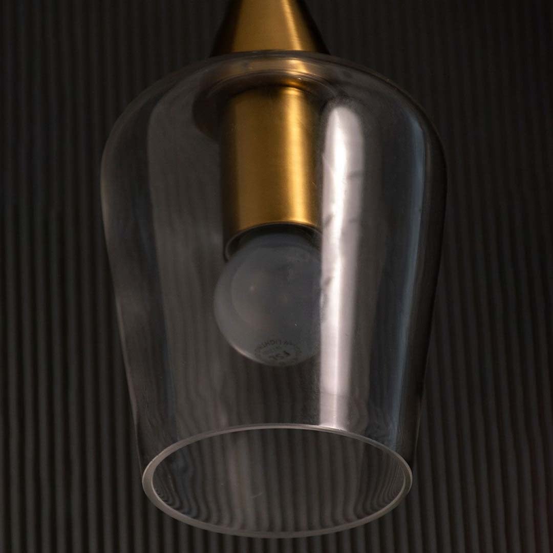A close view of the modern glass pendant light showing the gold top and clear glass shade capturing the bulb shape and premium detailing.