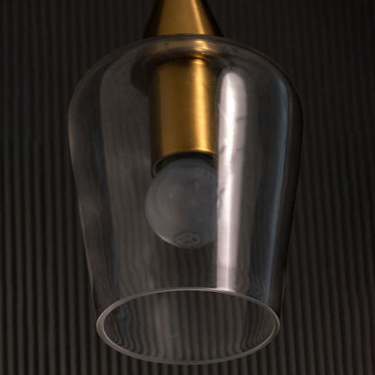 A close view of the modern glass pendant light showing the gold top and clear glass shade capturing the bulb shape and premium detailing.
