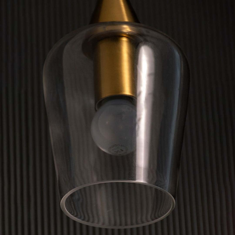 A close view of the modern glass pendant light showing the gold top and clear glass shade capturing the bulb shape and premium detailing.