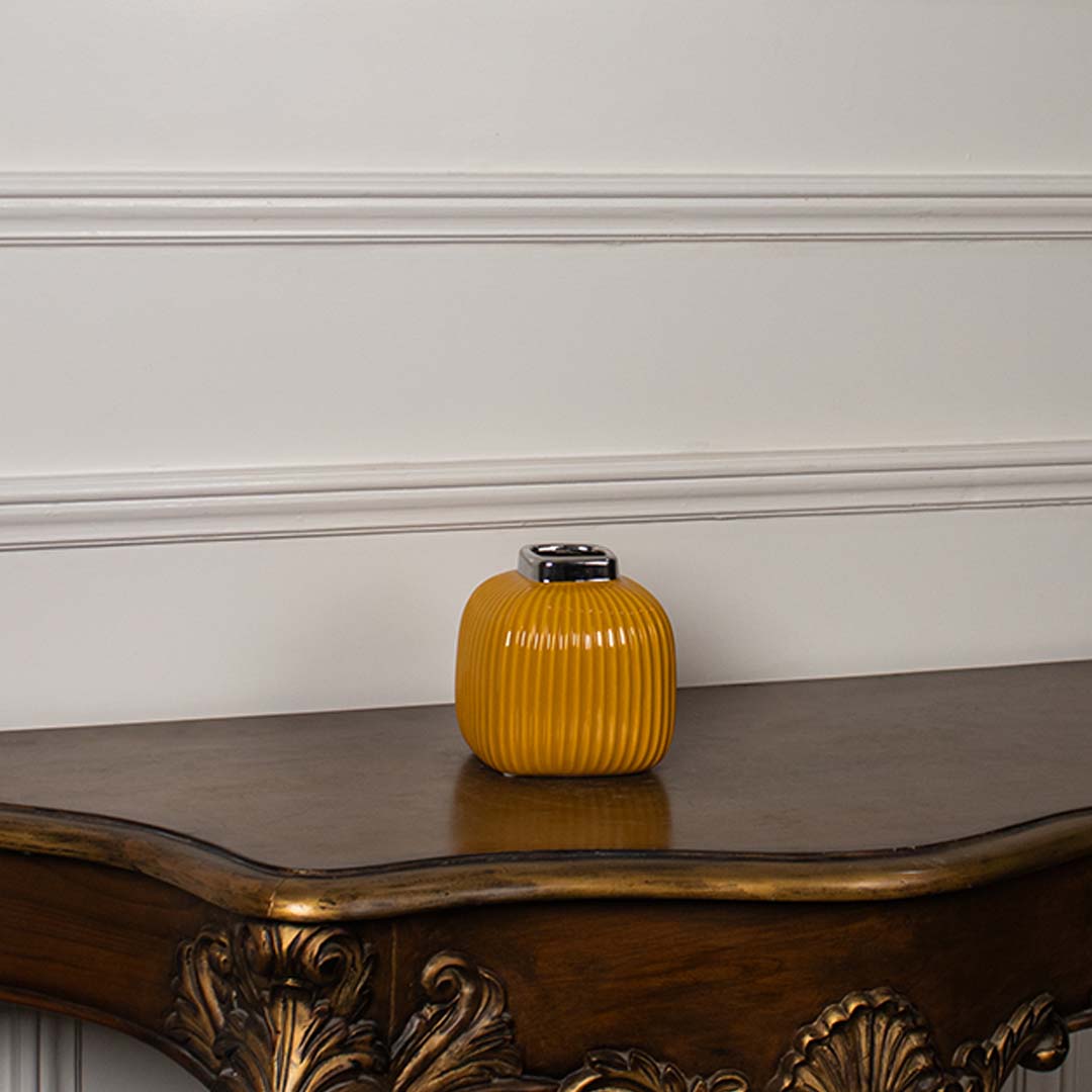 Yellow ribbed ceramic mini vase displayed on a clean white background highlighting its glossy top and modern shape.