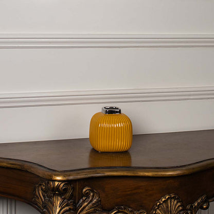 Yellow ribbed ceramic mini vase displayed on a clean white background highlighting its glossy top and modern shape.