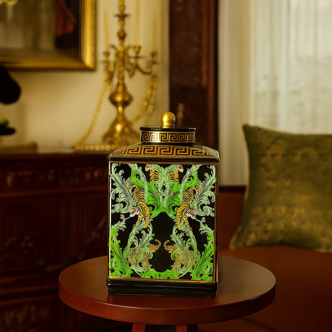 Black ceramic jar with golden and green tiger design adding a regal accent to luxury interior decor.
