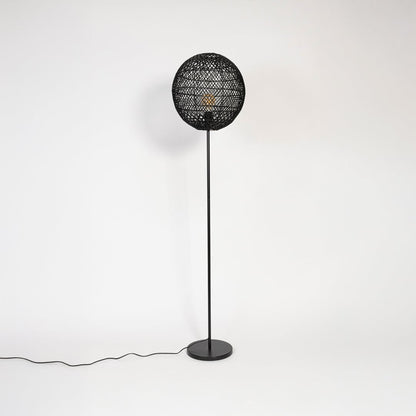 Black floor lamp with woven rattan globe shade turned off on plain white background stylish home accent.