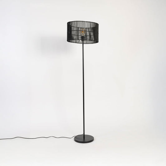 Black floor lamp with woven rattan shade switched off on white background decorative home lighting accent.