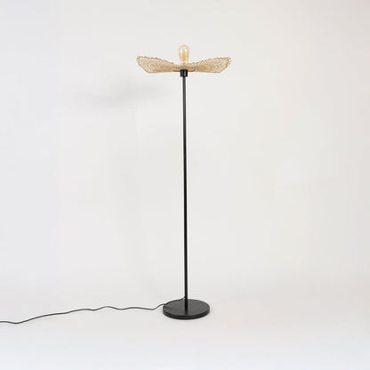 Black floor lamp with natural rattan leaf shade turned off on white background stylish decorative accent.