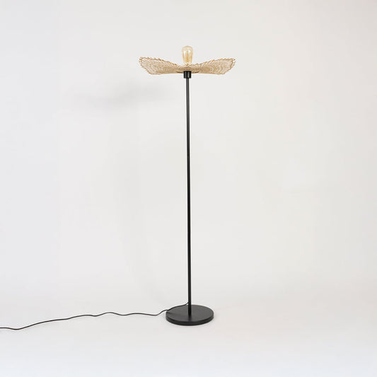 Black floor lamp with natural rattan leaf shade turned off on white background stylish decorative accent.