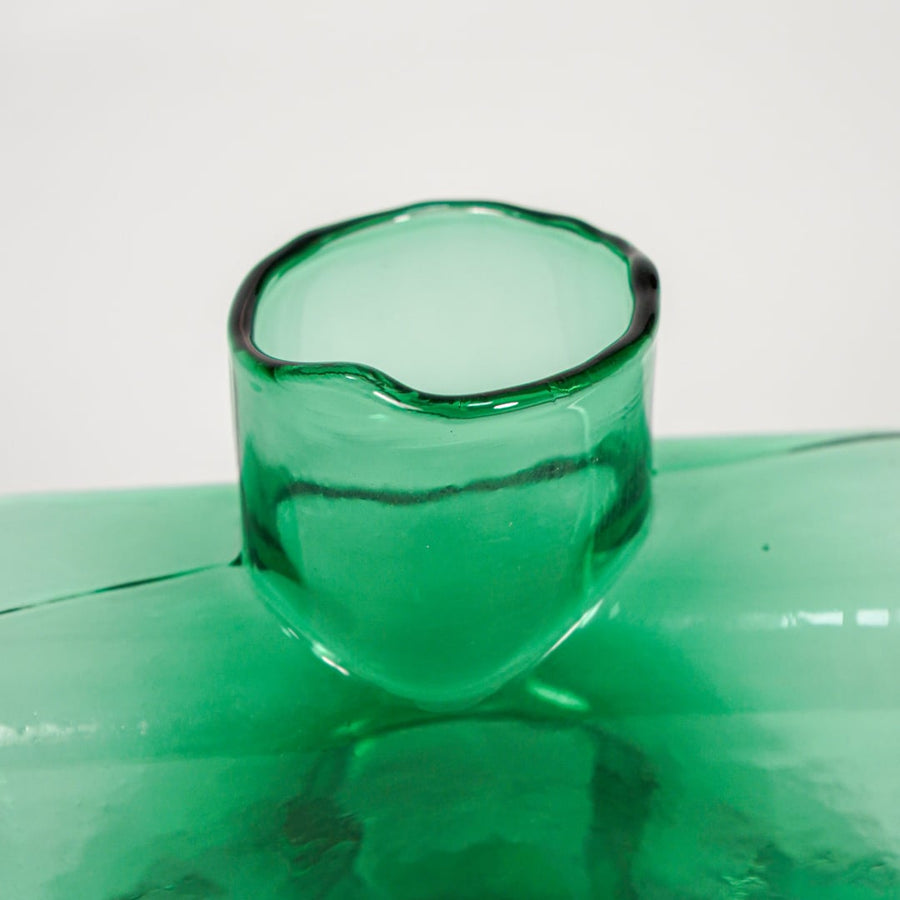 Close up view green art glass vase showing glossy sculpted surface modern decorative glass accent piece for shelf styling home.