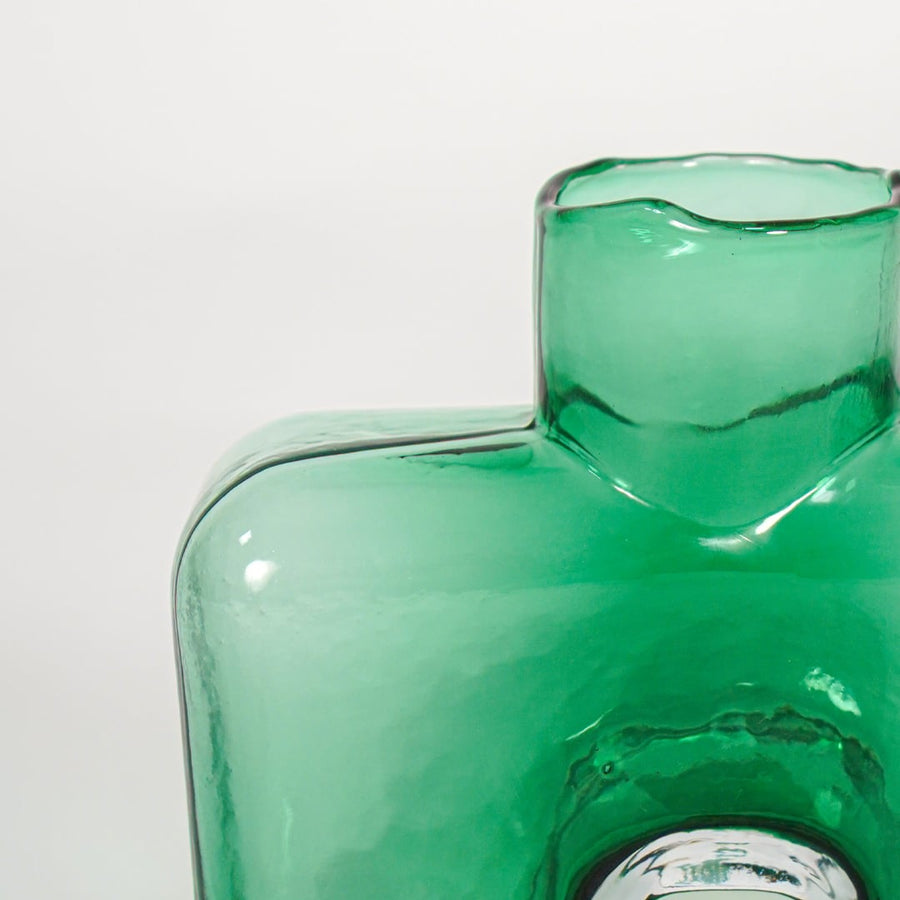 Close up view green sculpted glass vase with artistic form luxury decorative glass accent piece for console shelf styling home.