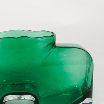 Close up view green sculpted glass vase with artistic shape modern decorative glass accent piece for shelf console styling home.