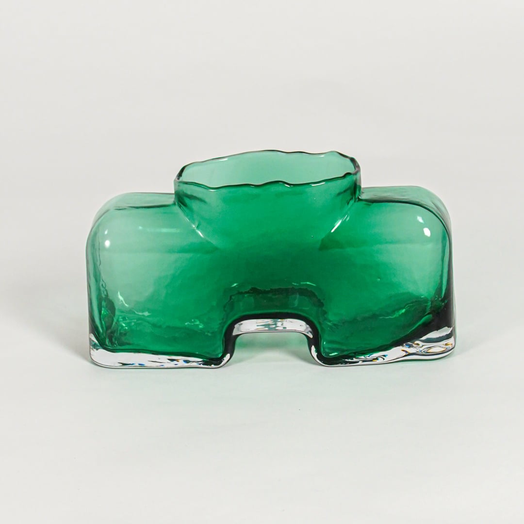 Green decorative art glass vase on white background modern home decor accent piece for table shelf console styling interior.