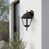 Decorative black metal outdoor wall lantern with clear glass for porch entrance balcony and exterior walls with warm lighting.